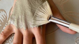 グリーンクレイペーストを刷毛でパックされる手