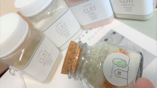 ICA認定クレイセラピスト養成講座のテキストとコルクの蓋のガラスの瓶に入ったクレイバス用クレイ