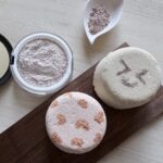 丸いクレイバスボムが２つ並んでいる。コンパクトに入ったクレイパウダーが置いてある。