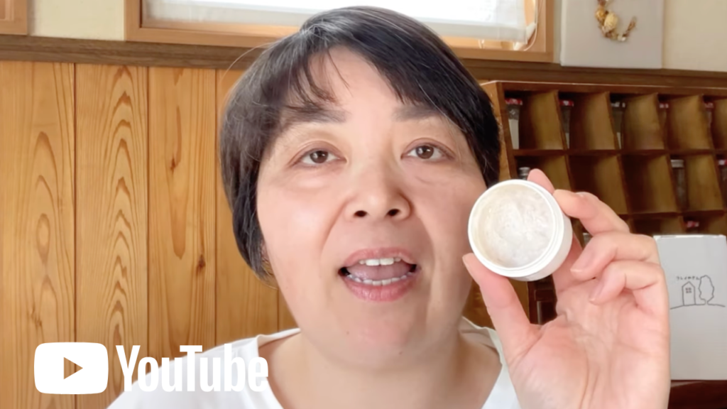 YouTube サムネ画像。クレイファンデーションを持って笑っているクレイセラピスト前島まり。